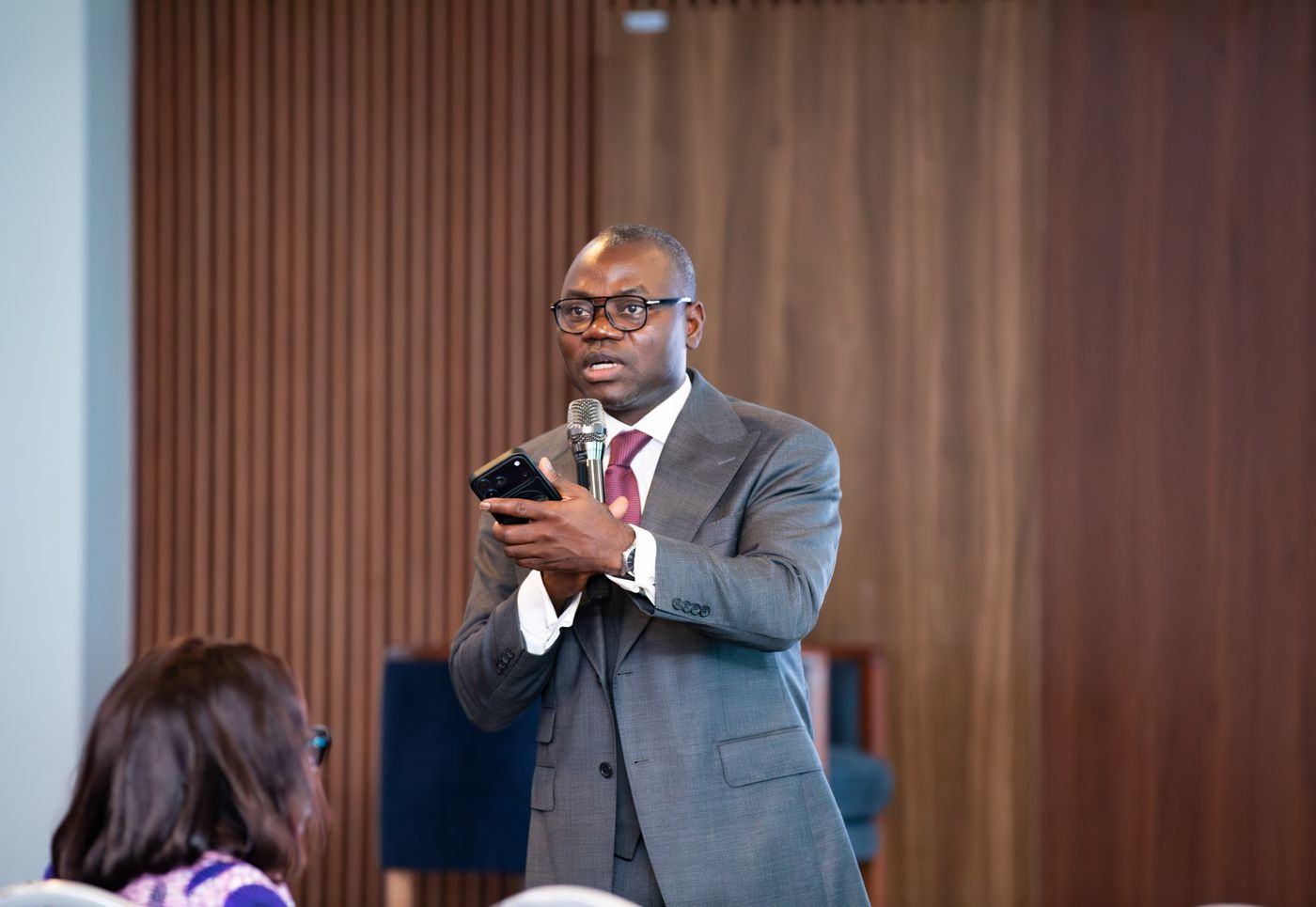 Speaker with a microphone addressing the room